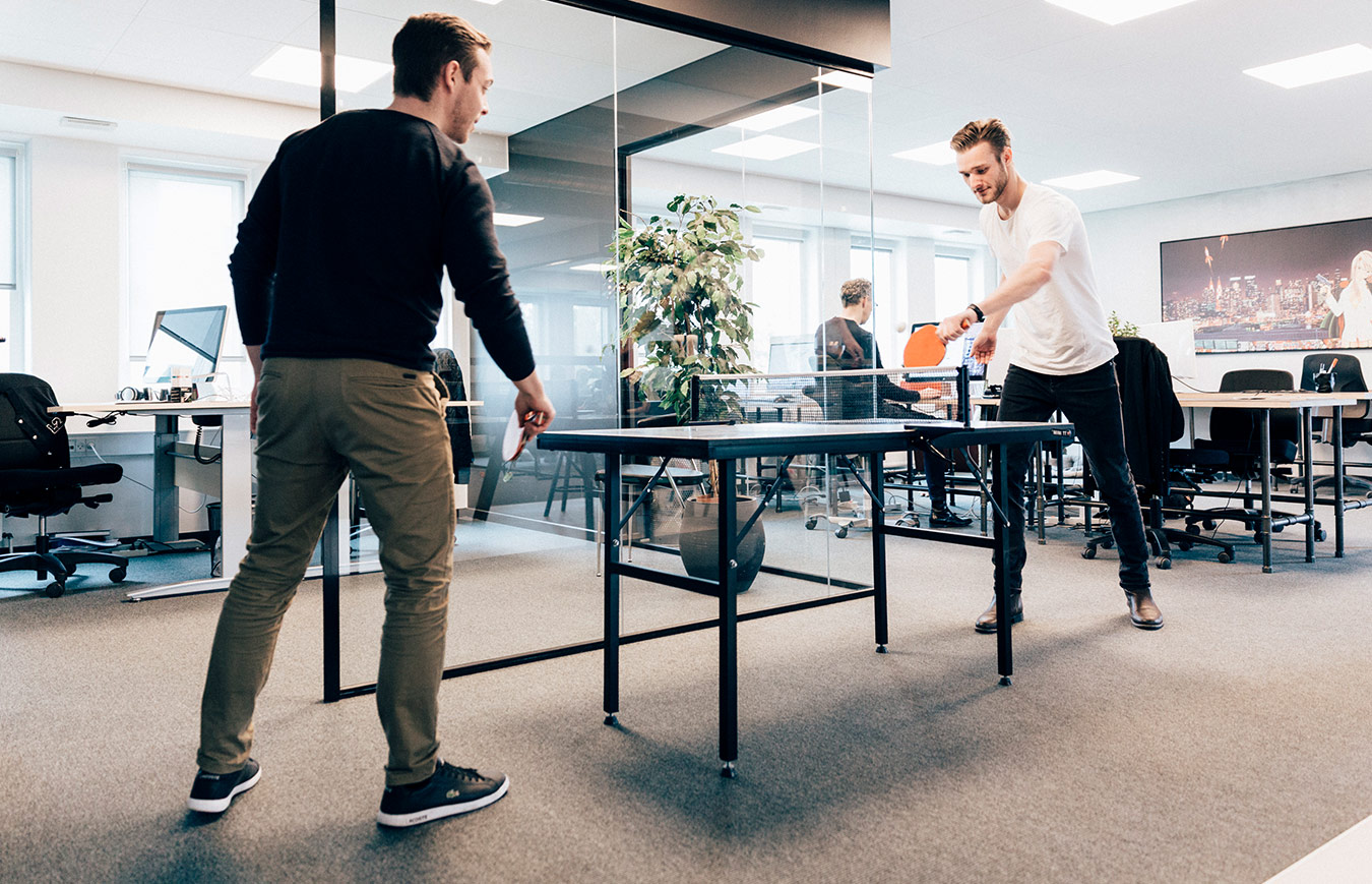 office fun - employees playing table tennis at work to relax